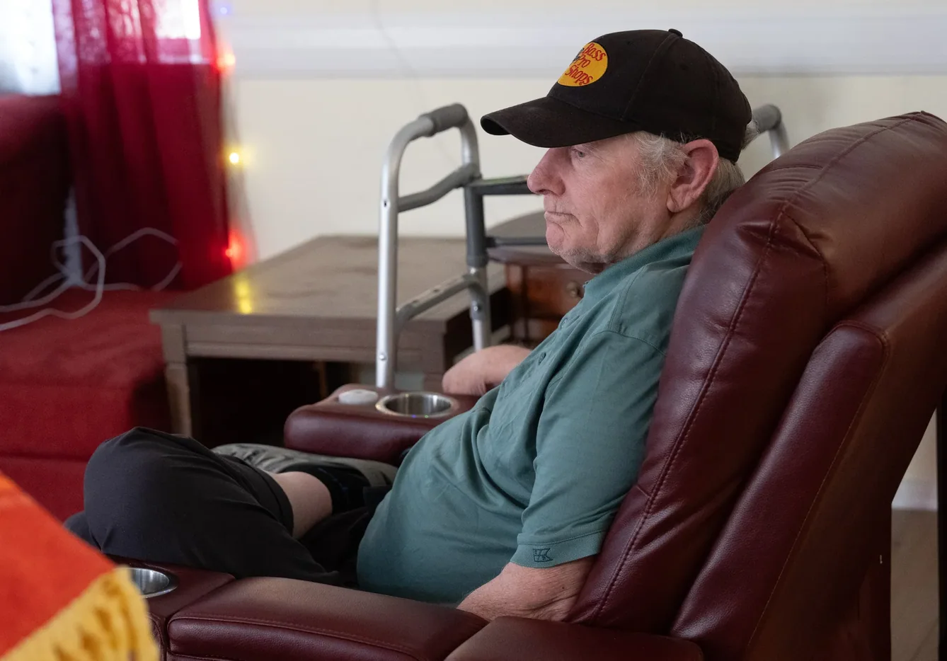 Senior resident sitting comfortably in recliner with walker accessible nearby in residential care home living room